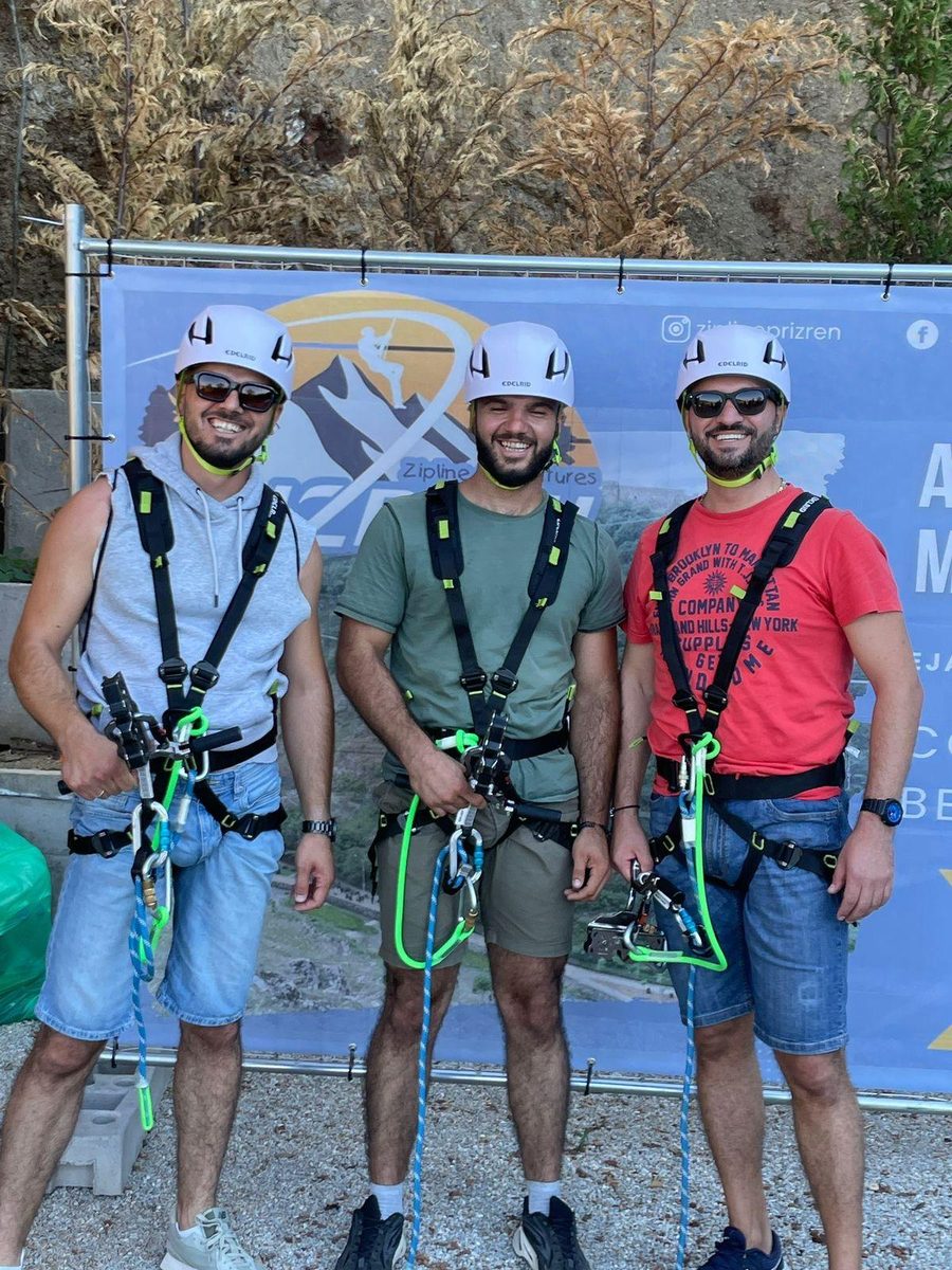 Three riders in helmets and harnesses, ready to fly